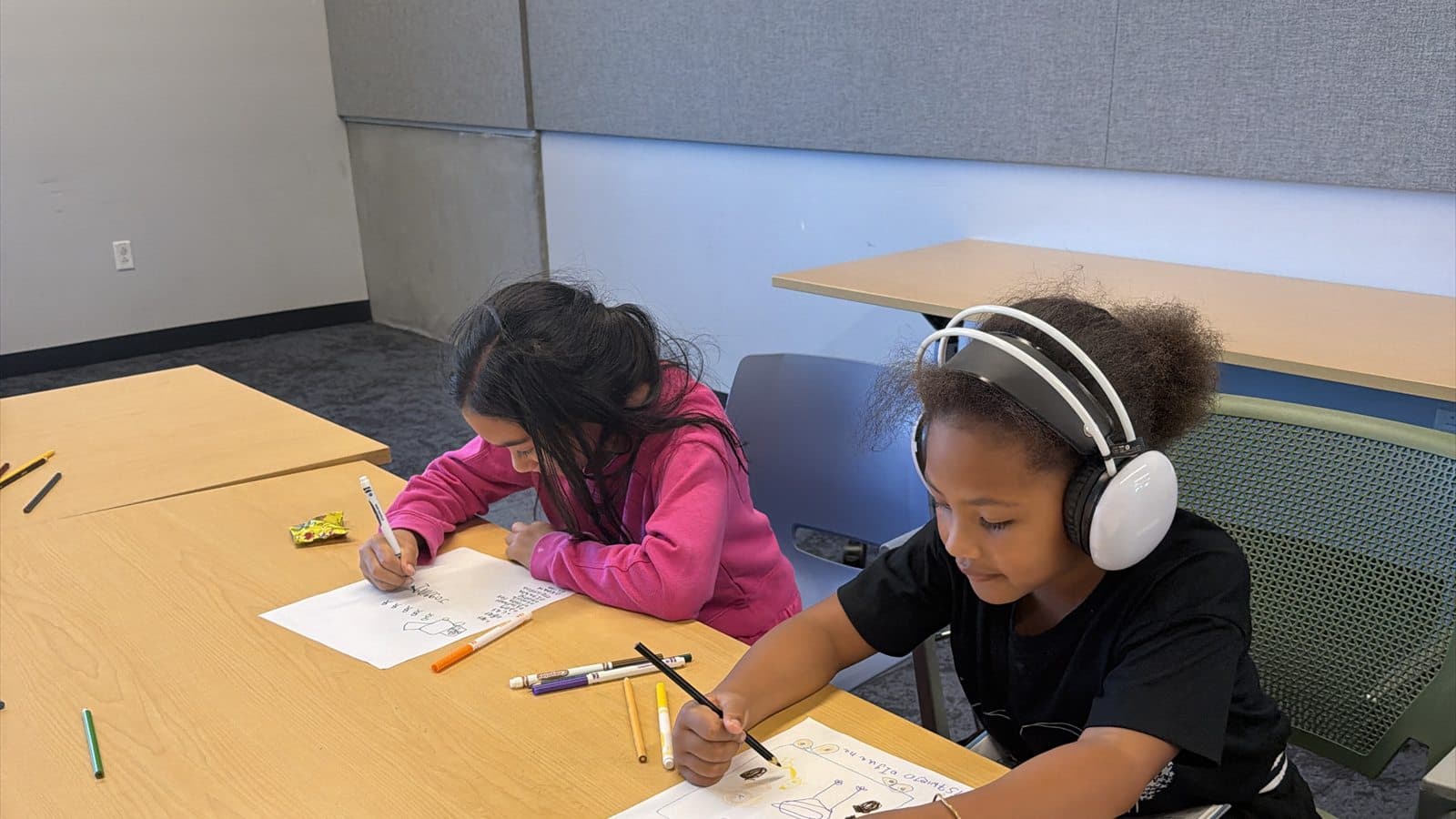Two children creating and writing together during a learning session.